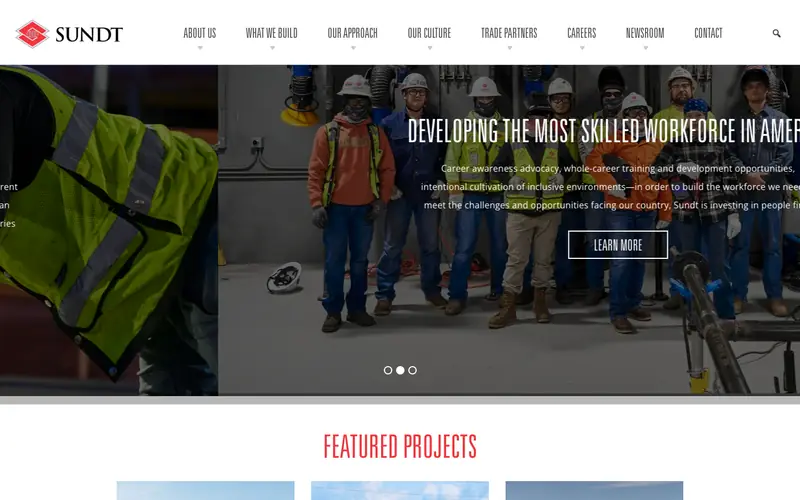 The Sundt Construction homepage with workers in safety vests and a Featured Projects heading